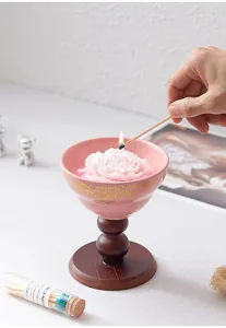 Prachtige roze geurkaars in een keramische kom met houten standaard voor gezellige huisdecoratie.