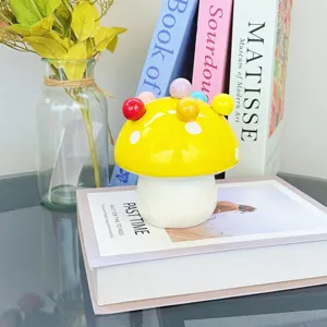 Cute ceramic mushroom storage jar with colorful fruit forks, perfect home table decor item.