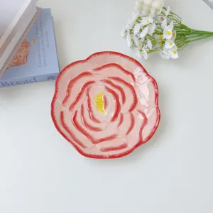 Close-up detail of the ceramic flower plate featuring exquisite pink petal textures and glaze.
