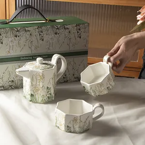 Set d'acqua in ceramica con elegante motivo floreale, teiera e tazze in confezione.
