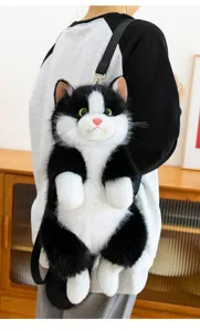 Close-up detail of black and white cat plush backpack showing soft fluffy fur and realistic eyes.
