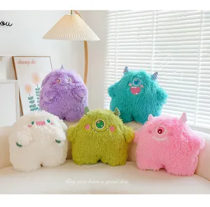 Detailed view of colorful cute fuzzy monster plush toys displayed on a cozy white sofa.