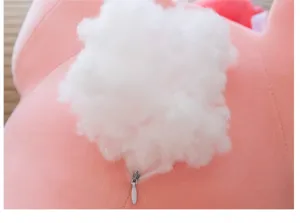 Dettaglio di un grazioso peluche rosa con coda soffice bianca e cerniera nascosta.