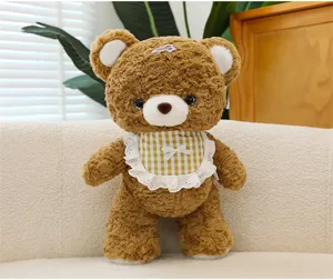 Detail shot of brown plush bear toy with cute checkered bib and hair clip for home decor.