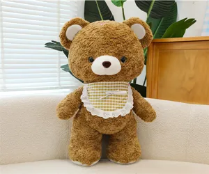 Close-up detail of the cute brown plush bear toy with a charming plaid bib and soft texture.