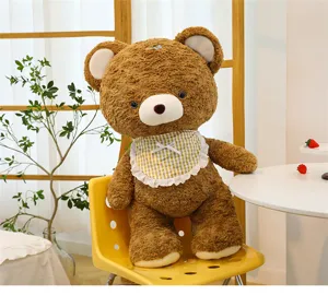 Cute mocha brown teddy bear plush toy detail shot, soft curly fur doll with lovely checkered bib.