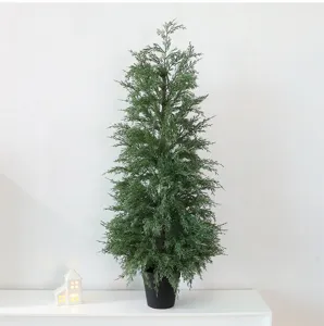 Detail view of a lush green artificial cypress Christmas tree in a black pot