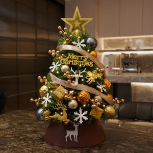 Exquisito árbol de Navidad de mesa decorado con luces cálidas y adornos dorados