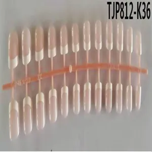 Vista dettagliata di unghie finte stile francese su supporto in plastica, forma ovale.
