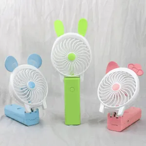 Close-up of cute foldable handheld mini fans with cartoon ears, USB rechargeable for cool summer.