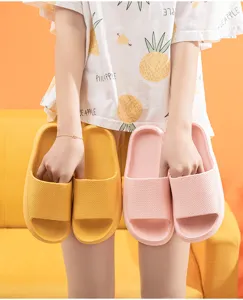 Close-up detail of soft thick platform slide slippers in yellow and pink for daily comfort.