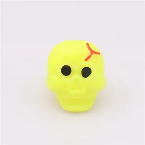 Primo piano del dettaglio dell'anello teschio in plastica gialla per festa di Halloween.