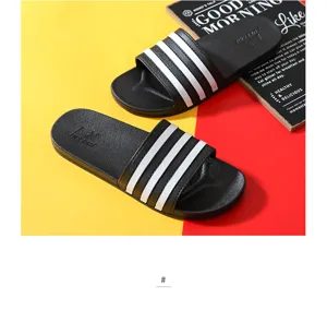 Black slide sandals for men and women, anti-slip bathroom slippers with classic three-stripe design.