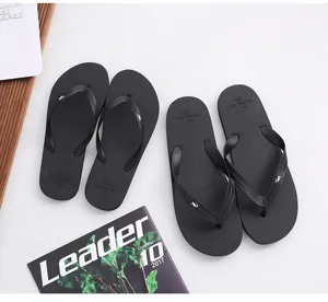 Classic black couple flip-flops, simple design, comfortable beach slippers for summer.