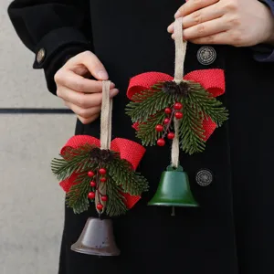 Pair of rustic Christmas bell ornaments with red burlap bow and pine branch details