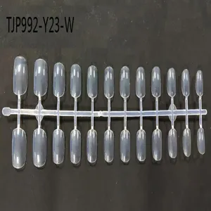 Detail shot of clear plastic false nail tips on a strip, unpainted short square round design.