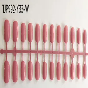 Pink short square false nail tips on sprue, un-oiled press-on display set for DIY nail art.