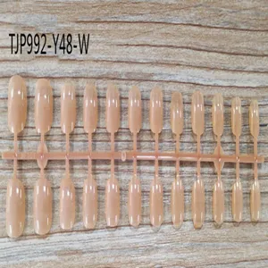 Detailed view of short square unpainted false nail tips arranged on a plastic strip for DIY art.