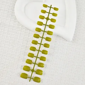 Short square fake nail tips in olive green, uncut strip design for DIY nail art design.