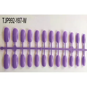 Short square purple fake nail tips detail view, unpolished press on nail supplies on runner.