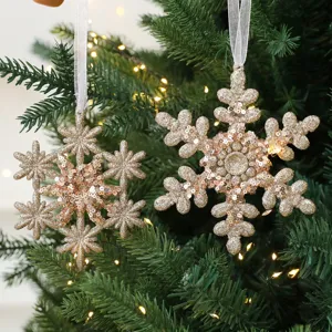 Elegante champagnegouden pailletten sneeuwvlok kerstornamenten hangend aan de boom