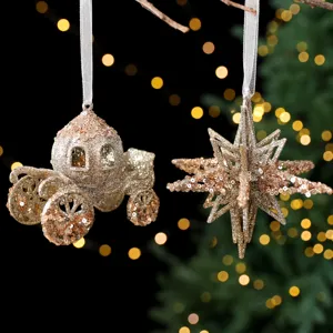 Champagnegouden kerstversieringen in de vorm van een koets en een ster met pailletten decor