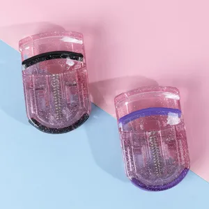 Primer plano de rizadores de pestañas de plástico rosa brillante con almohadillas suaves.