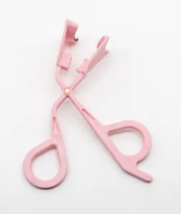 Pink plastic eyelash curler detail view, compact makeup tool for easy daily eye styling.