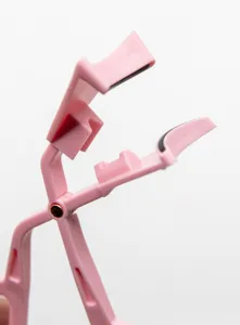 Close-up detail of the pink plastic magnetic eyelash curler applicator tool, showing structure.