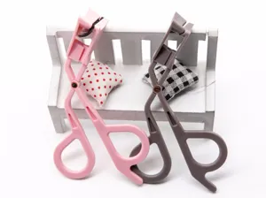 Portable plastic magnetic eyelash curler detail view, ergonomic handle design for easy curling.