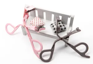Detail view of magnetic false eyelash curlers in pink and gray, creative mini bench props.