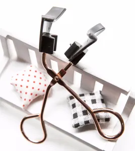 Detailed view of the magnetic metal eyelash curler with black plastic precision styling heads.