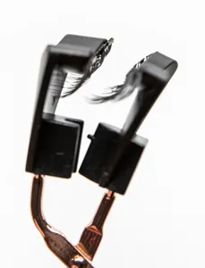 Detailed view of a magnetic eyelash applicator tool with black plastic head and rose gold handle.
