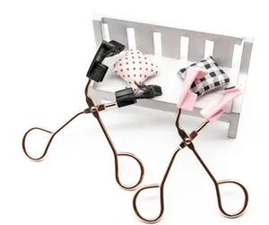 Close-up detail of magnetic eyelash curler with rose gold handles and convenient magnetic clips.