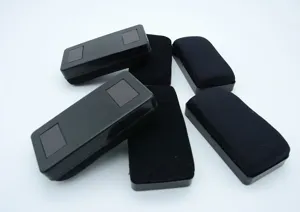 Magnetic whiteboard eraser with black felt surface, durable plastic shell for office use.