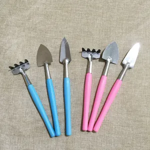 Mini gardening tool set details showing cute pink and blue handles with metal shovel and rake heads.