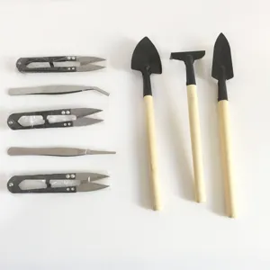 Set di attrezzi da giardinaggio in miniatura con forbici, pinzette, cazzuola e rastrello.