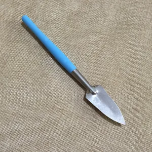 Mini garden tool metal shovel with blue plastic handle detail close-up view for plants