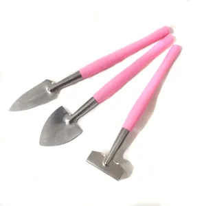 Mini gardening tool detail shot, showing pink handle shovel and rake for potted plants.