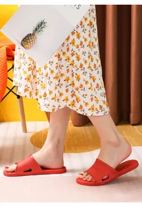 Close-up detail of red rubber slide slippers featuring breathable cutout design and comfortable sole.