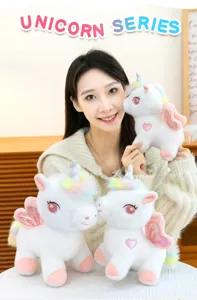 Morbido peluche unicorno arcobaleno con ali e cuore, grazioso giocattolo imbottito.