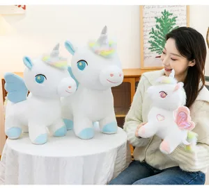 Morbido peluche unicorno arcobaleno con ali e corno glitterato, regalo ideale per bambine e ragazze.