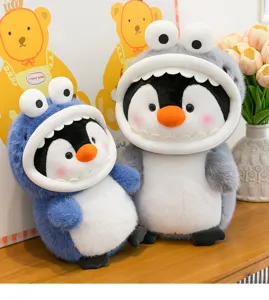 Close-up detail of cute shark costume penguin plush toys set displayed on wooden desk.