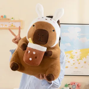 Cute capybara plush toy holding bubble tea cup with rabbit ears headband, soft stuffed doll gift.