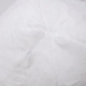 Detalle de juguete de felpa blanca, textura de tela suave y esponjosa con cremallera.