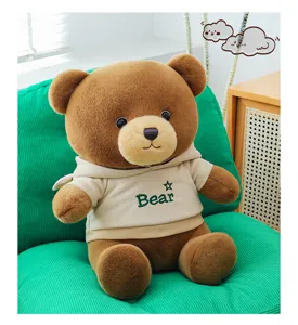 Cute brown teddy bear plush doll in a beige hoodie, detailed shot of soft toy pillow for girls.