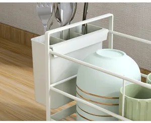 Primer plano detallado del escurridor de platos de cocina con cubitera y cuencos blancos y verdes.