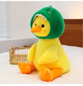 Close-up detail of cute yellow duck plush toy wearing green dinosaur hood, soft bedroom scene.