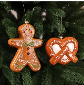 Close-up detail of gingerbread man and pretzel shaped Christmas ornaments hanging on a tree