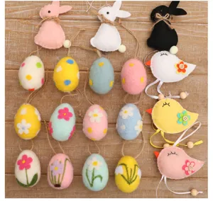 Variety of colorful handmade wool felt Easter eggs rabbits and birds decorations on wood